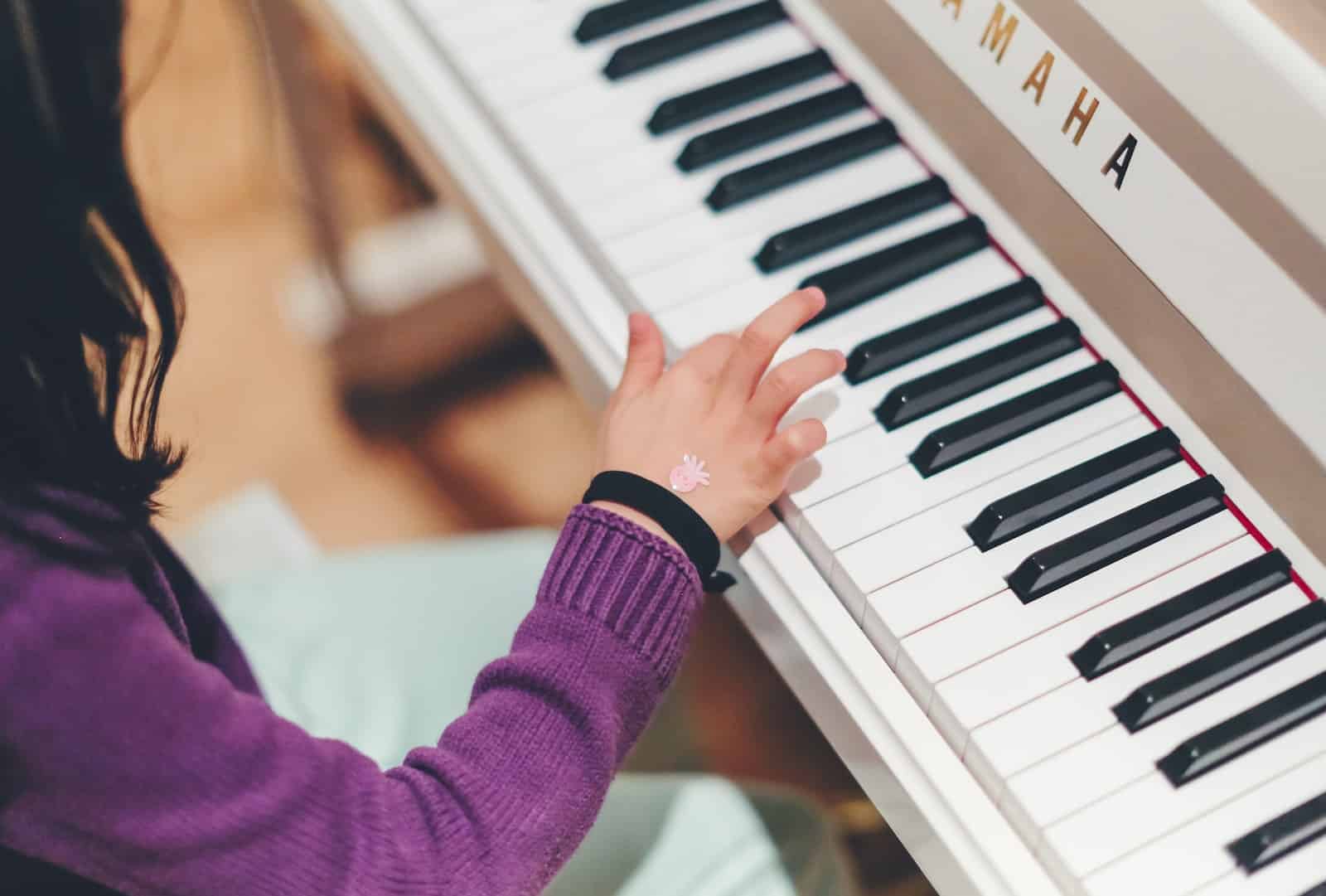 person playing piano | 13 Tips for Motivate Child to Practice Musical Instruments